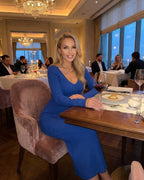 Maris Midi Dress by Lauven worn in a stylish restaurant setting, featuring a blue ribbed knit V-neck design.