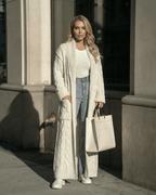 Milano Cardigan by Lauven, a long cable-knit wool blend layer styled with jeans and a tote bag in an urban setting.