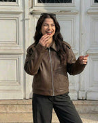 Smiling woman wearing a Milano Jacket by Lauven, a stylish brown leather jacket for fall casual wear.