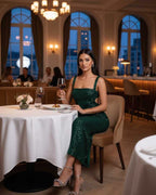 Model wearing Lauven Nara Midi Dress in Emerald Green with sequined straps at a classy restaurant.
