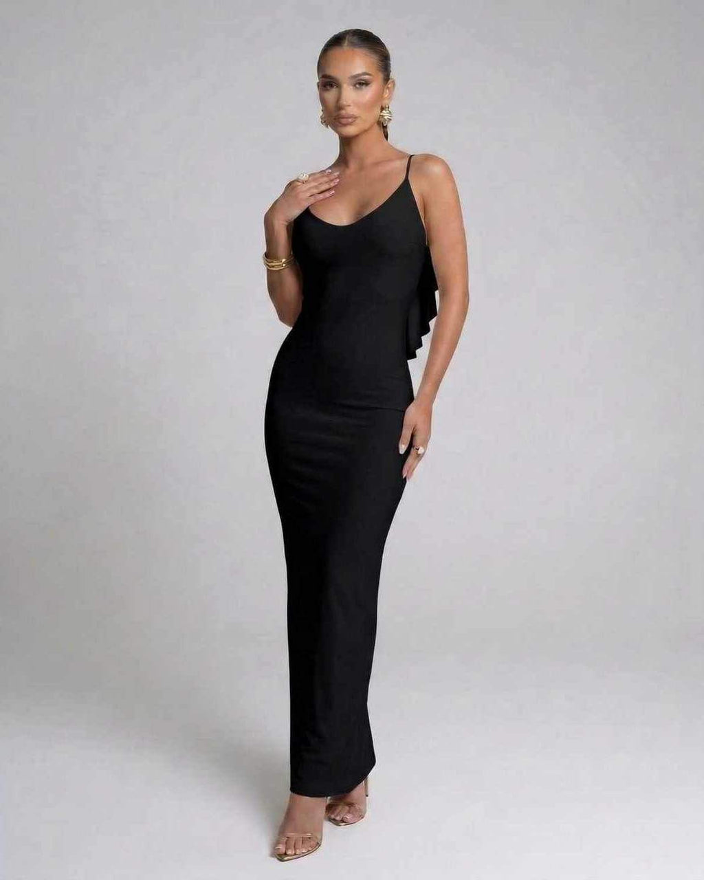 Model wearing the Nocturne Maxi Dress by Lauven, a classic black spaghetti strap evening gown.