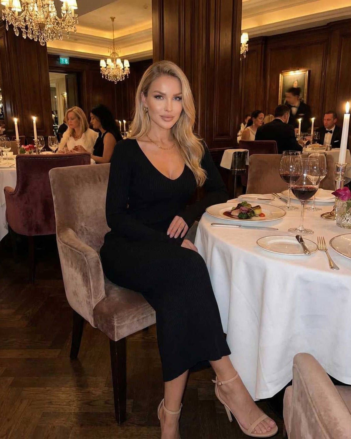 Noir Midi Dress by Lauven worn by a woman at an elegant dinner setting, showcasing its sophisticated design.