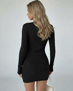Back view of a model wearing the Noir Mini Dress by Lauven, showcasing its fitted design and long sleeves.