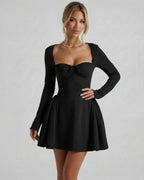 Noir Mini Dress by Lauven features a square neckline, long sleeves, ruched bow detail, and a flared silhouette in elegant black.