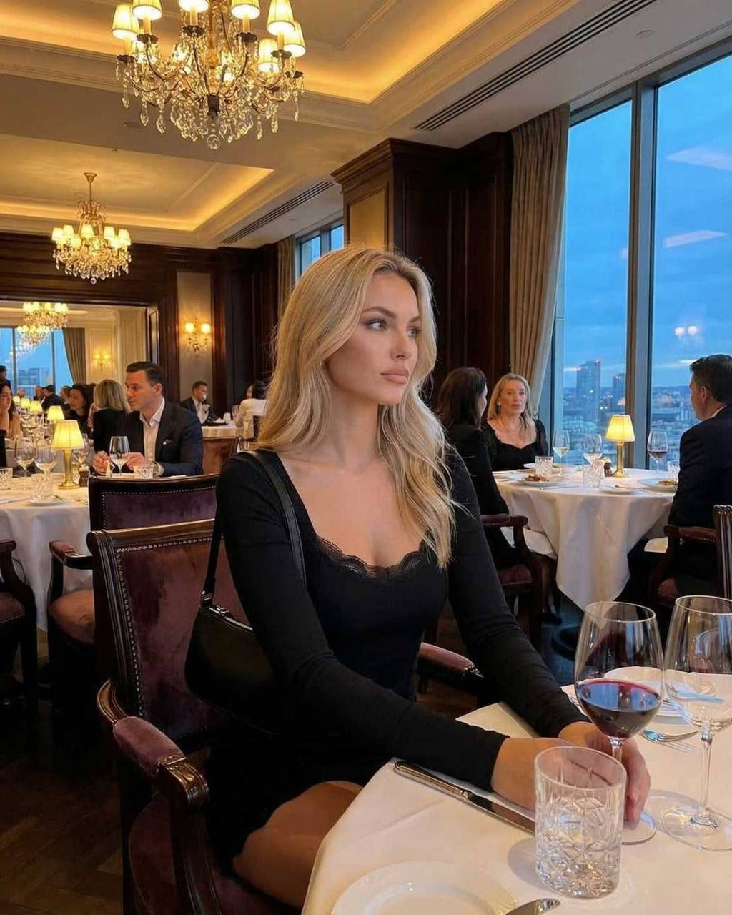 Noir Mini Dress styled in a chic restaurant setting, featuring long sleeves, lace trim, and a smooth silhouette, by Lauven.