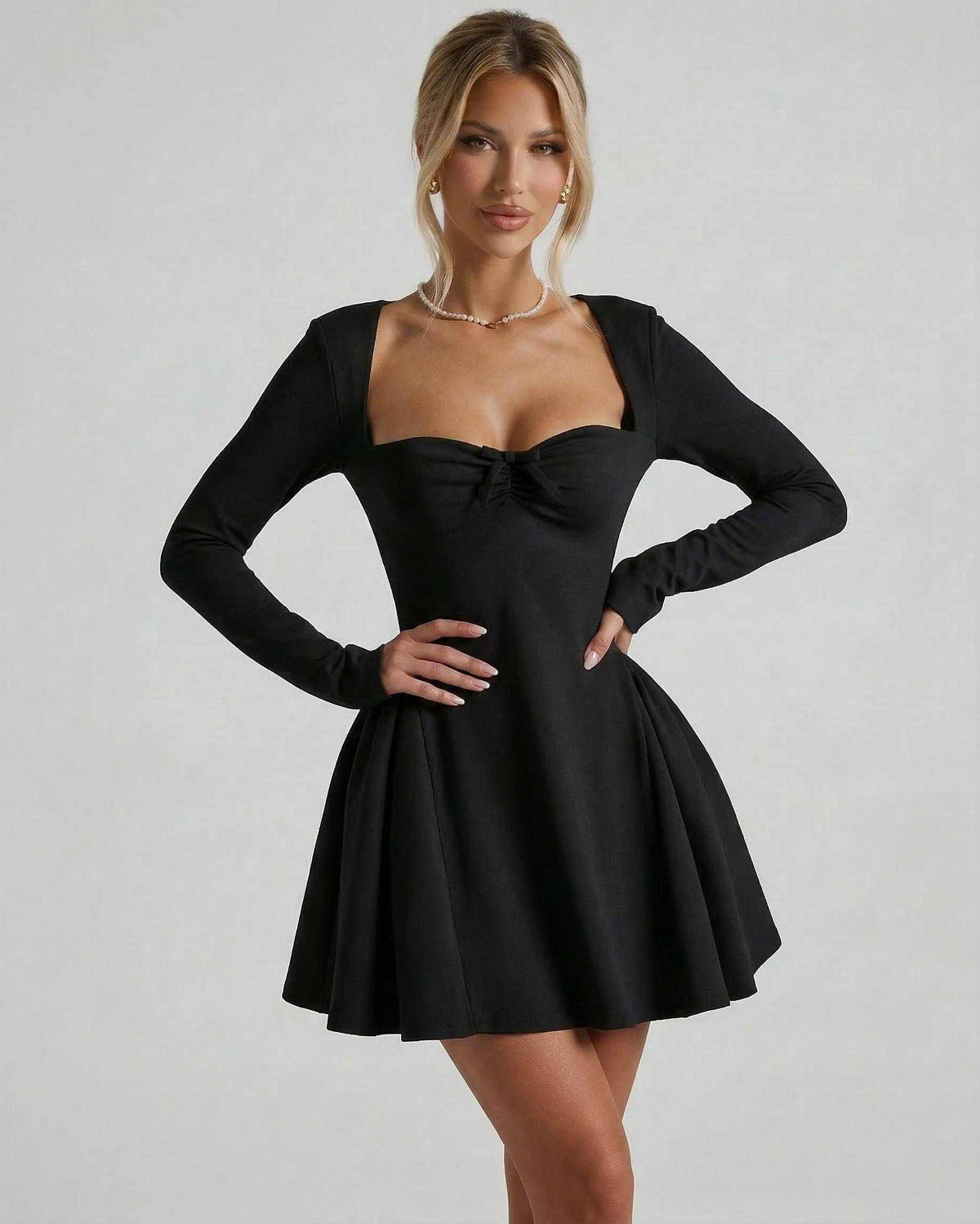 Noir Mini Dress by Lauven, elegant black long sleeve with ruched bow detail and flattering fit-and-flare silhouette.