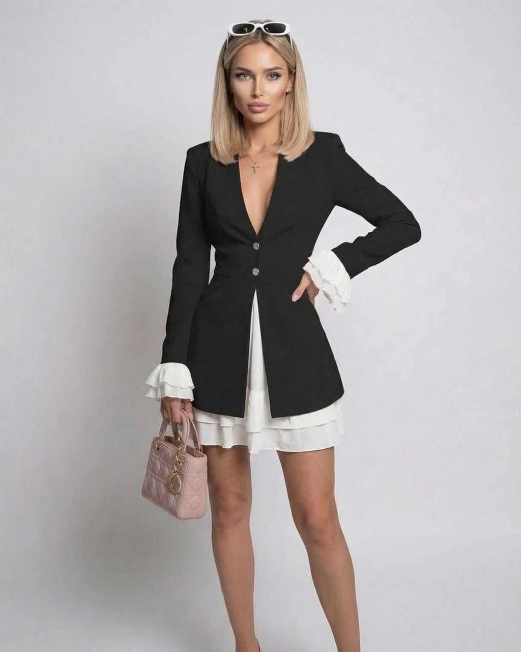 Noir Mini Dress showcasing ruffle contrast and deep V-neck by Lauven, elegant black fabric with white cuffs.