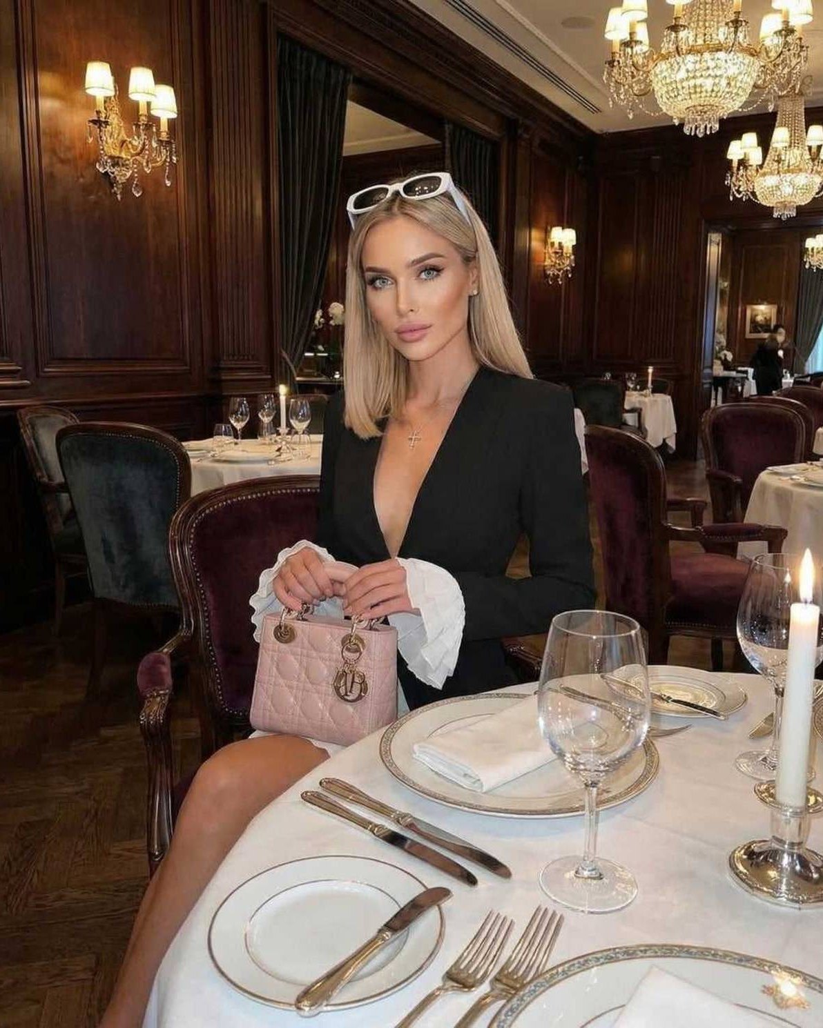 Noir Mini Dress with ruffle cuffs and deep V-neck, featuring a sophisticated look by Lauven in an elegant dining setting.
