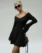 Model wearing a Lauven Noir Mini Dress, a slim fit black knit with V-neck and flared sleeves.