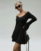 Model wearing Noir Mini Dress by Lauven, a slim fit black knitted dress with V-neckline and flared sleeves.
