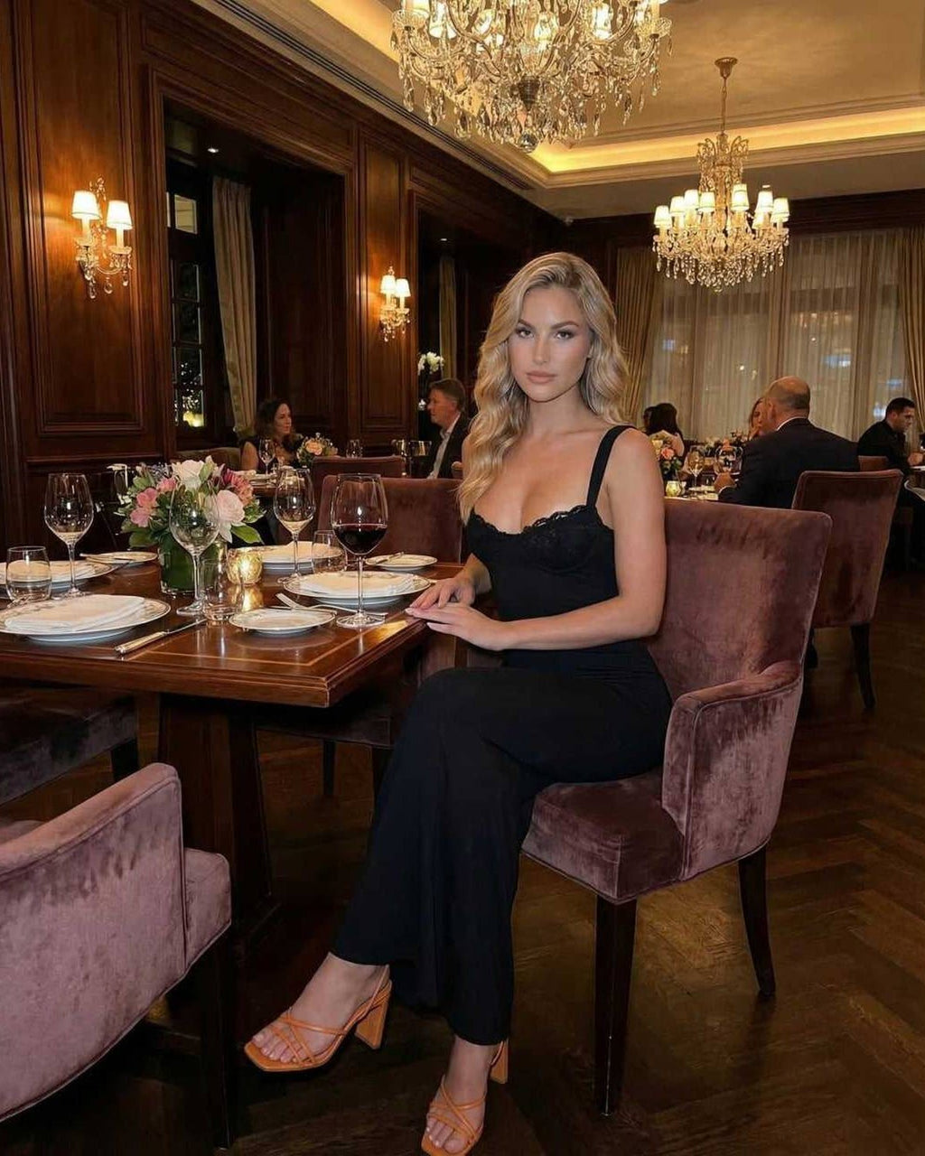 Noiré Maxi Dress worn by a woman in a classy restaurant setting showcasing sleek black satin elegance.