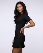 Noiré Mini Dress showcased in black, featuring a ribbed knit texture, ruffle hem, and stylish tie neck by Lauven.