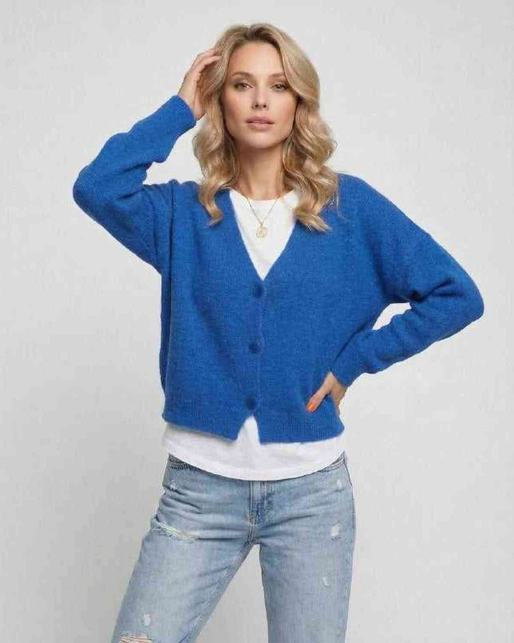 Model wearing a vibrant blue Nova Cardigan from Lauven, showcasing its relaxed fit and cozy knit style.