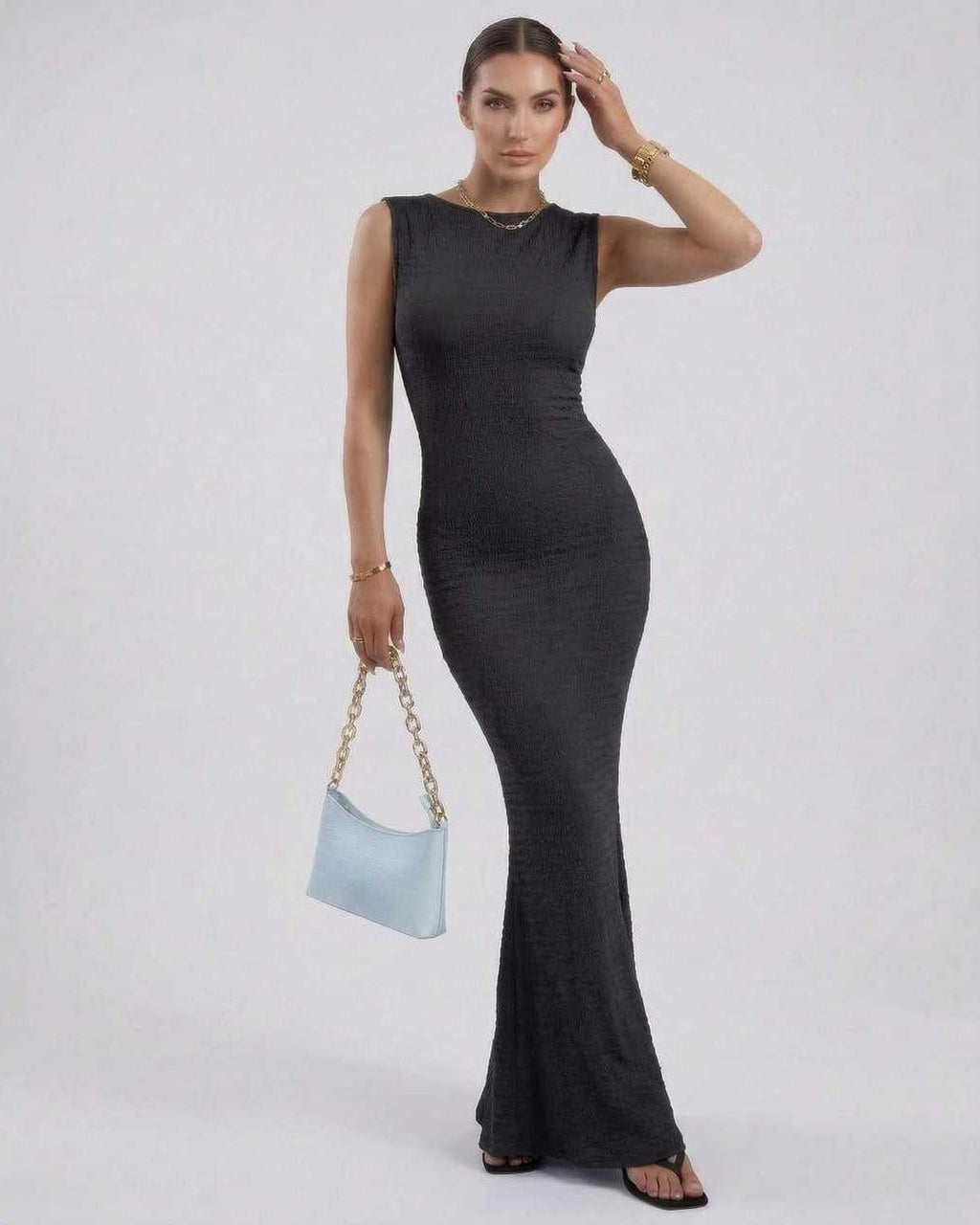 Model wearing a Nova Maxi Dress by Lauven, a black sleeveless ankle-length pencil dress with a sleek silhouette.