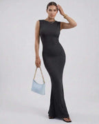 Model wearing a Nova Maxi Dress by Lauven, a black sleeveless ankle-length pencil dress with a sleek silhouette.