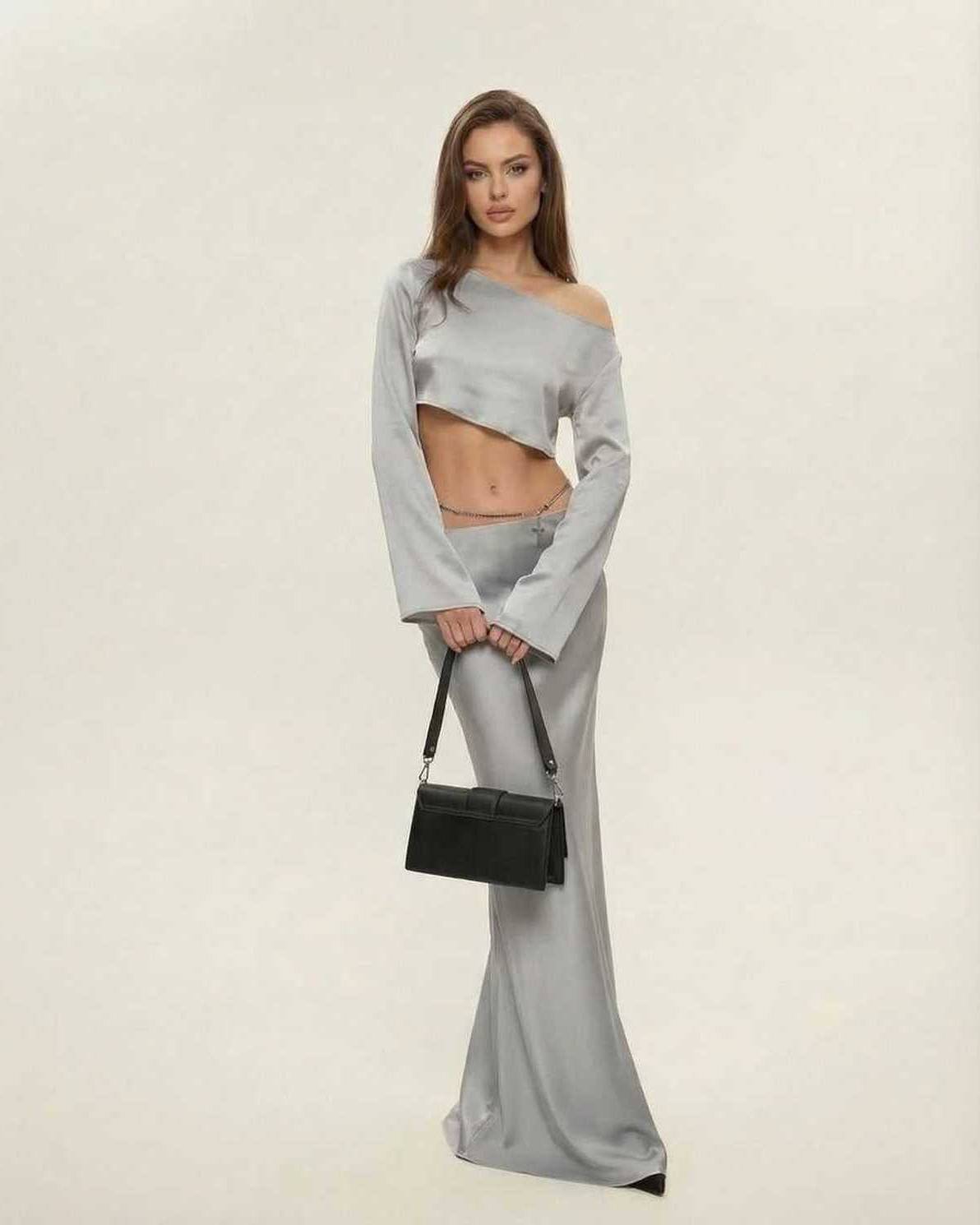 Model wearing Nova Midi Dress by Lauven, featuring an elegant asymmetrical silhouette in sleek silver.