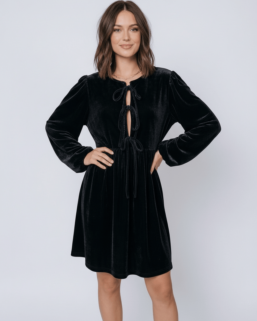 Model wearing Onyx Mini Dress by Lauven, a sleek black velvet princess dress with drawstring detail.