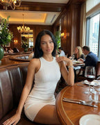 Orion Mini Dress by Lauven, a chic ribbed knit white mini dress with a sleek silhouette and modern cross back detail.