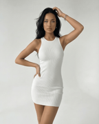 Orion Mini Dress by Lauven – White ribbed knit mini dress with cross back detail and sleeveless design.