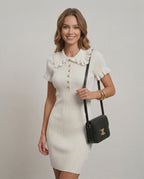 Ivory Knit Dress by Lauven worn by a model featuring a ruffle collar and decorative buttons.