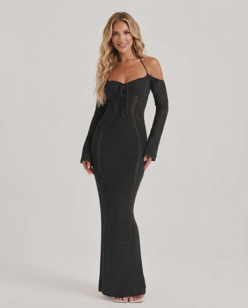 Model wearing Noir Maxi Dress, a black long sleeve bodycon gown with open back halter design by Lauven, showcasing elegant style.