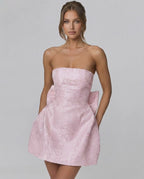 Blush Mini Dress by Lauven featuring a strapless neckline and elegant bow detail in luxurious jacquard fabric.