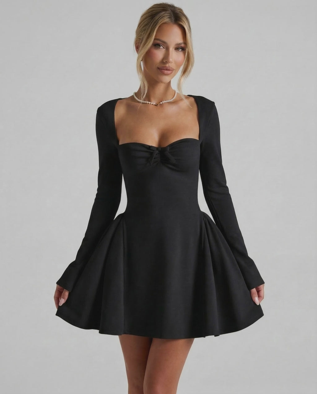Noir Mini Dress showcasing a flattering fit-and-flare silhouette, long sleeves, and ruched bow detail by Lauven.