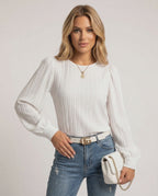 Celeste Blouse by Lauven, elegant white pleated long sleeve top worn with denim jeans and stylish accessories.