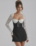 Bianca Lace Dress by Lauven, a black mini dress with white lace sleeves, combining elegance and modern style.