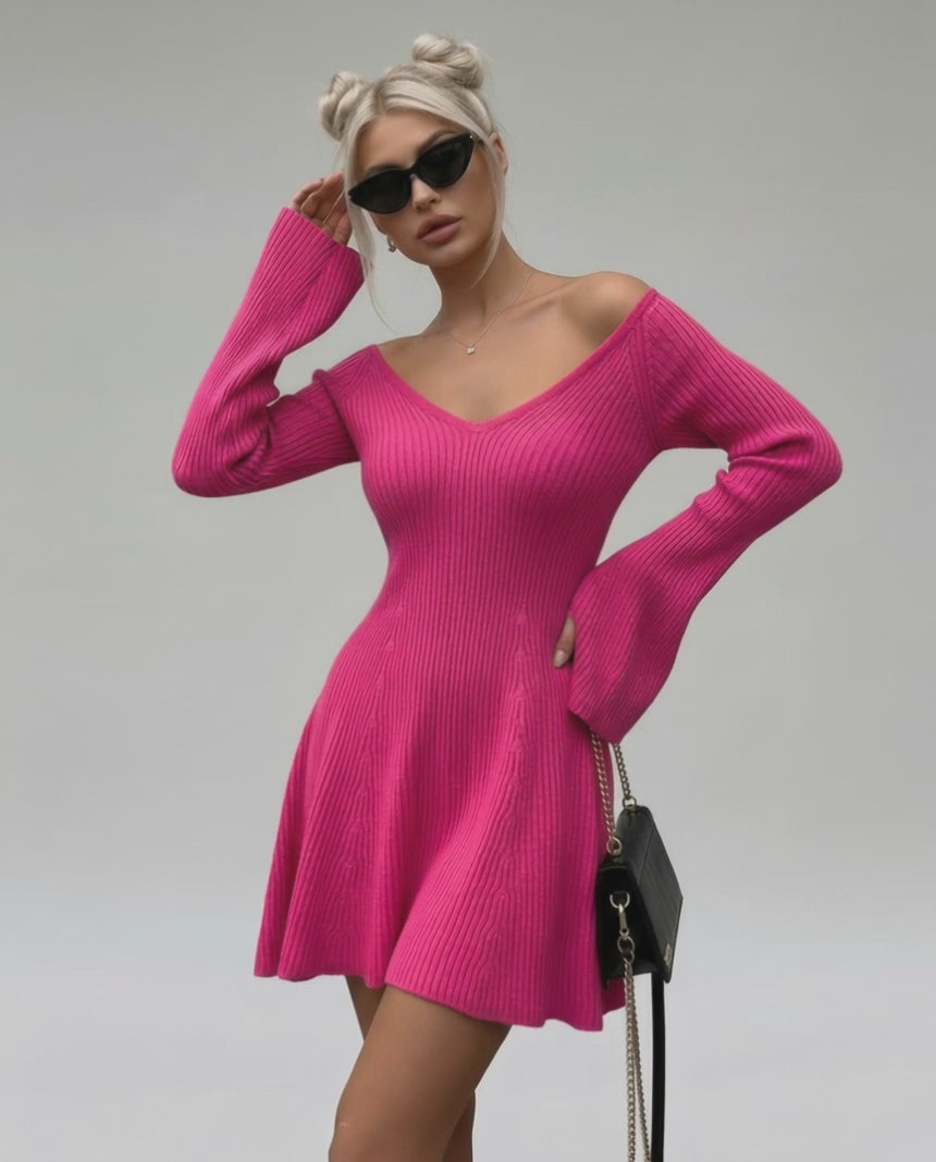 Model wearing Fiora Mini Dress by Lauven, a slim fit pink knit dress with V-neck and flared sleeves.