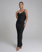 Model wearing Nocturne Maxi Dress by Lauven, a classic black spaghetti strap evening gown, showcasing elegant silhouette.