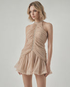 Elara Mini Dress by Lauven featuring ruching and sequin details, halter neckline in beige with a flowing skirt.