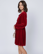 Ruby Mini Dress by Lauven, featuring a red velvet fabric, long lantern sleeves, and a flowy skirt.