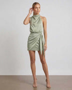 Sahara Mini Dress by Lauven – Elegant satin mini dress in soft sage green with draped high neck and wrap tie detail.