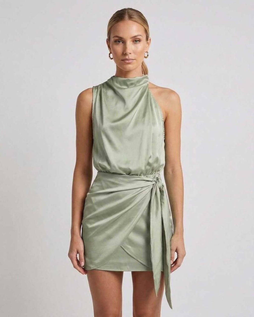 Sahara Mini Dress by Lauven, elegant satin mini dress with draped high neck and wrap tie detail in sage green.