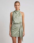 Sahara Mini Dress by Lauven, elegant satin mini dress with draped high neck and wrap tie detail in sage green.