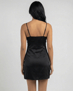 Back view of a woman wearing the Selene Mini Dress by Lauven, featuring slender straps and a sleek silhouette.