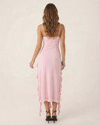 Back view of the Seren Midi Dress by Lauven in soft pink with flirty ruffle trim and spaghetti straps.