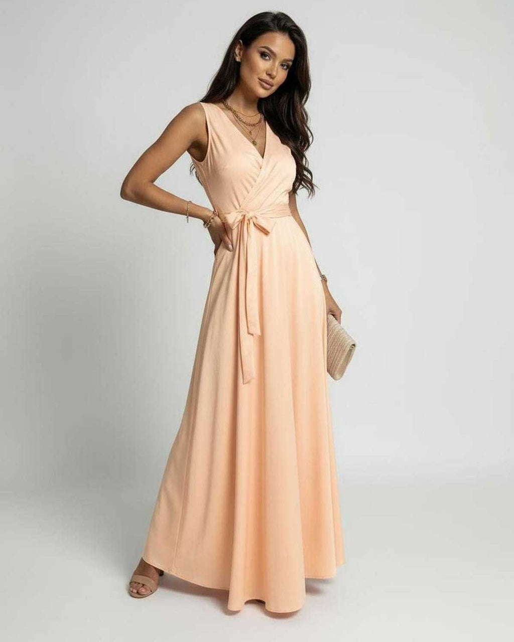 Woman wearing the Serena Maxi Dress by Lauven in soft peach, featuring a V-neck design and flowing silhouette.