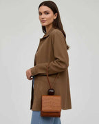 Sienna Jacket by Lauven displayed on a model, featuring a brown oversized design with a chic bag.