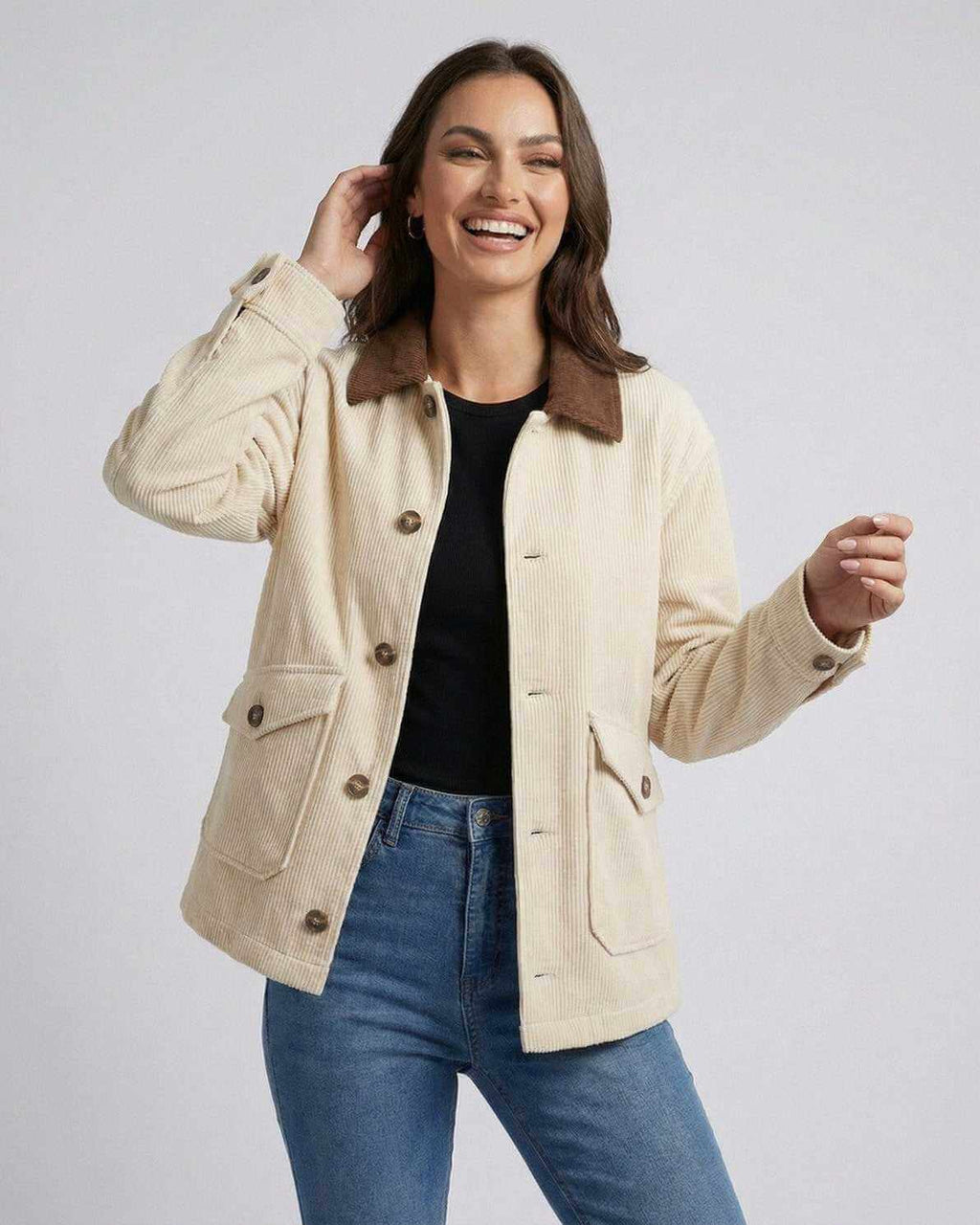 Smiling woman wearing the Sienna Jacket by Lauven, a cream oversized jacket with contrast lapel collar.