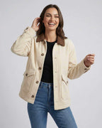 Smiling woman wearing the Sienna Jacket by Lauven, a cream oversized jacket with contrast lapel collar.