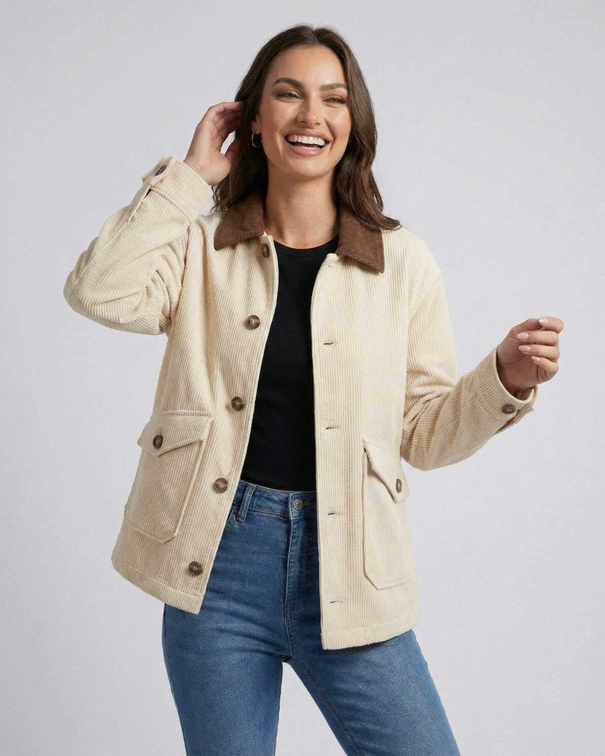 Smiling woman wearing the Sienna Jacket by Lauven, a cream oversized jacket with contrast lapel collar.