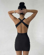 Back view of a model wearing the Lauven Sienna Mini Dress in black ribbed knit, showcasing its sleek sleeveless design.