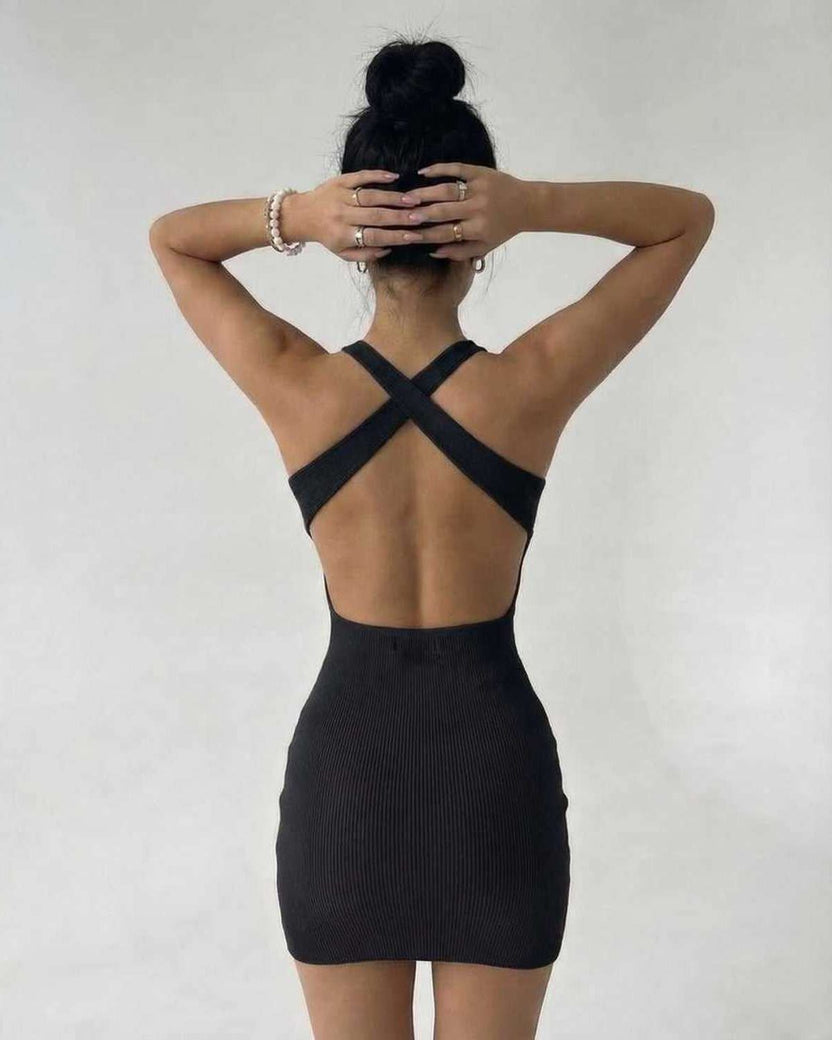 Back view of a model wearing the Lauven Sienna Mini Dress in black ribbed knit, showcasing its sleek sleeveless design.
