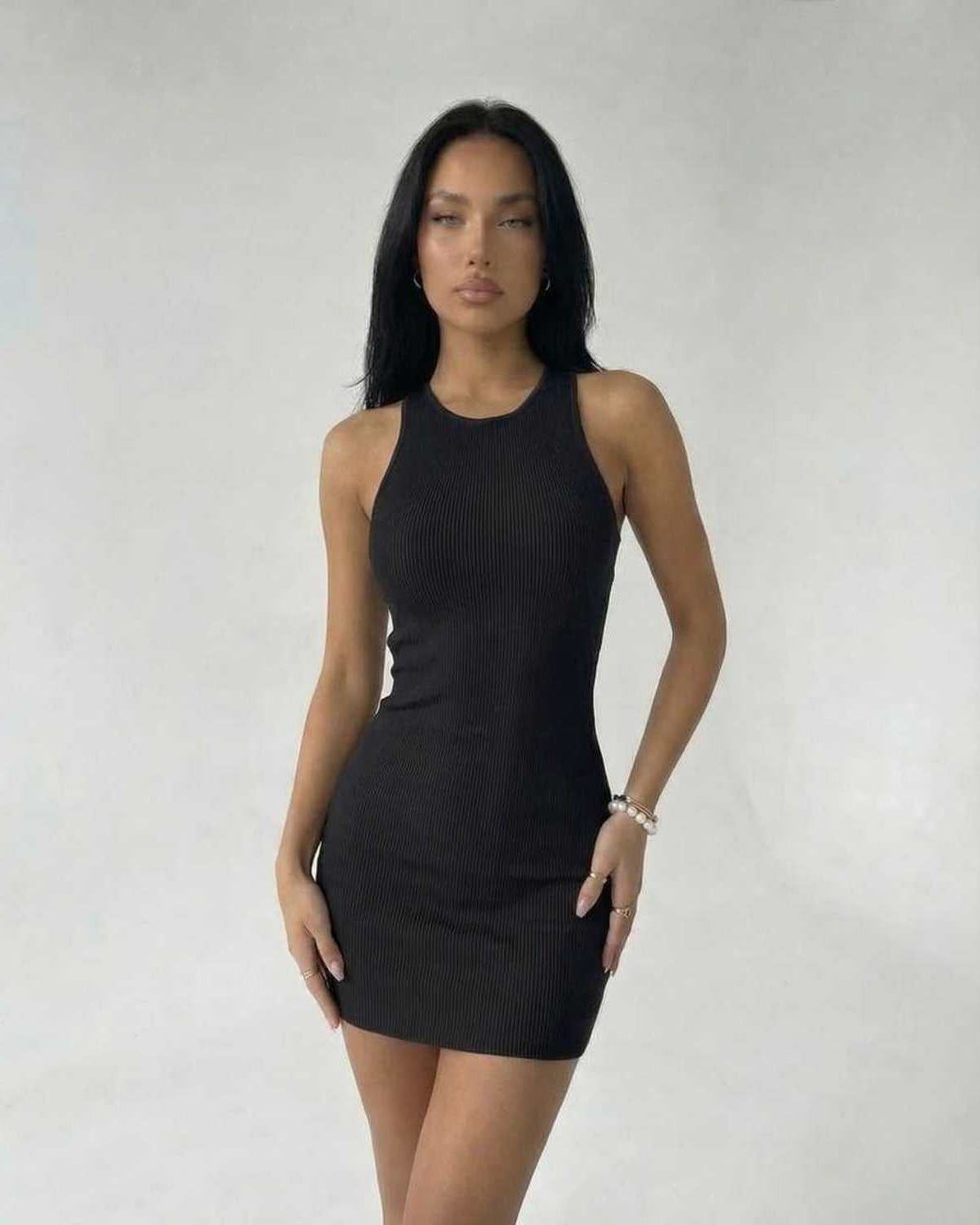 Model wearing the Sienna Mini Dress by Lauven in black ribbed knit, showcasing a sleek and modern sleeveless bodycon style.