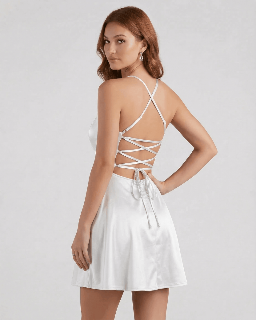 Model wearing the Silver Satin Mini dress by Lauven, featuring delicate spaghetti straps and a laced back design.