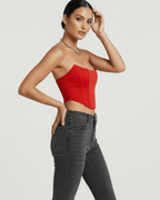 Model wearing the Solara Corset Top in vibrant red, a stylish design by Lauven, showcasing structured elegance.