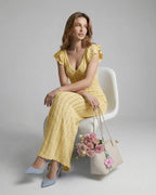 Model showcasing the Solara Maxi Dress by Lauven, a yellow lace maxi with V-neck and ruffle sleeves.