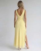Solara Maxi Dress showcasing the elegant yellow fabric, ruffle slit, and flowing silhouette by Lauven.